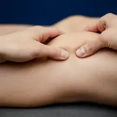 Fizjoterapeuta wykonuje masaż rzepki, kluczowy element rehabilitacji rzepki ćwiczenia.
