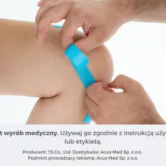 Ręce aplikują niebieskie tejpy na kolano, by wspomóc gojenie siniaków.