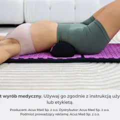 Kobieta leży na fioletowej macie do akupresury, która pomaga jej w relaksacji.