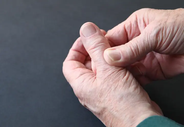 Dłoń wykonuje ćwiczenia na zespół de Quervaina, masując bolesny kciuk.